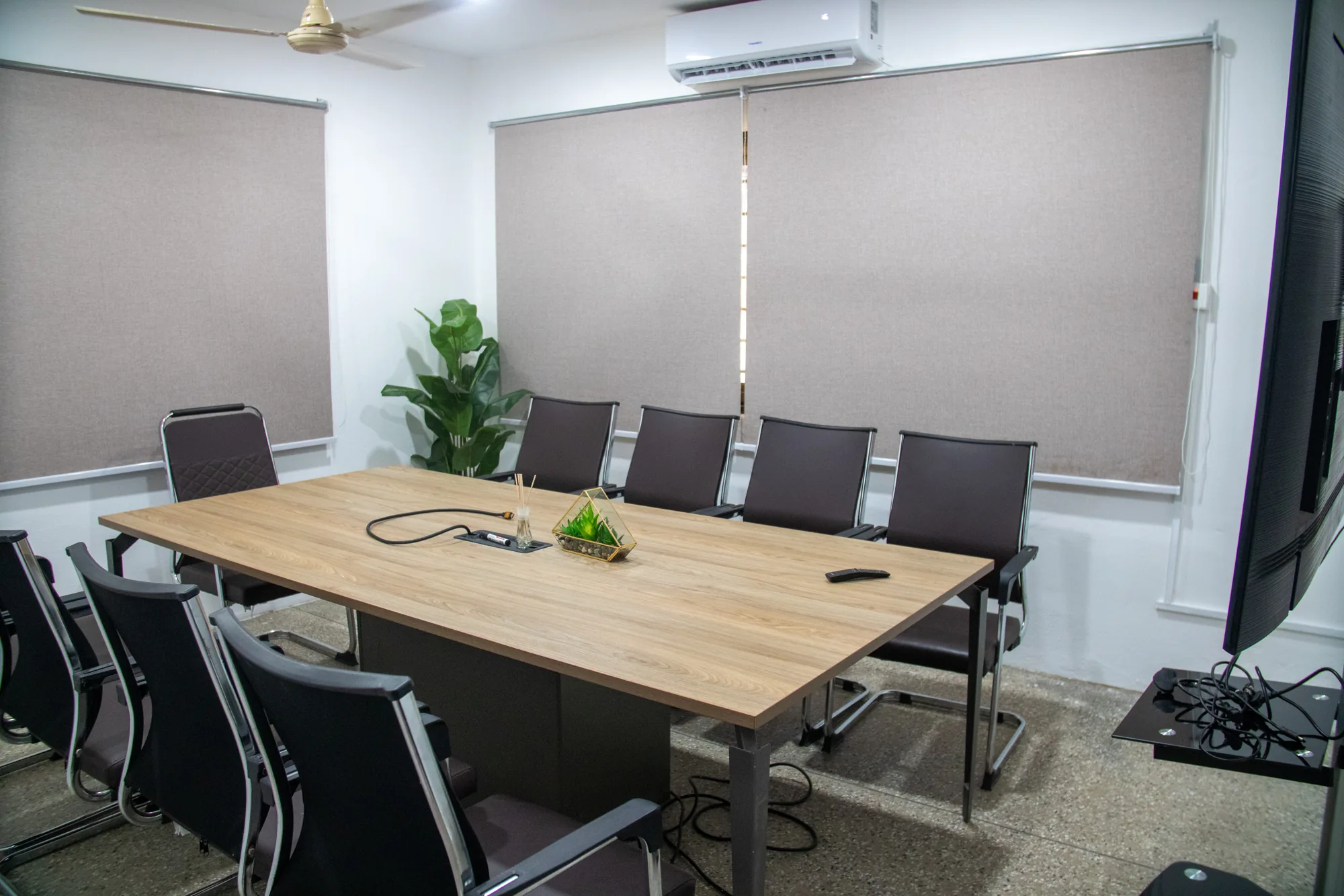 Meeting table with executive chairs and window blinds at yecSpace