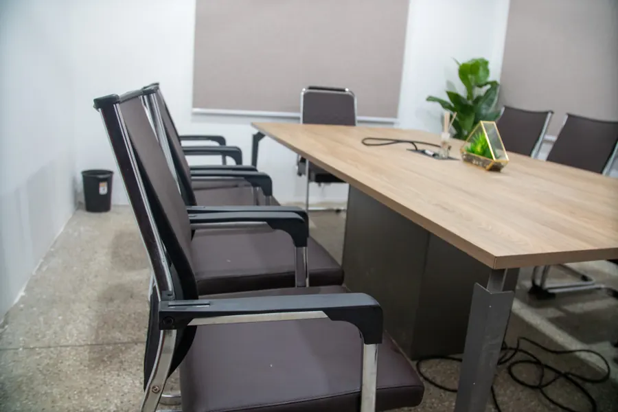 A closer view of the meeting room chairs and wooden table at yecSpace