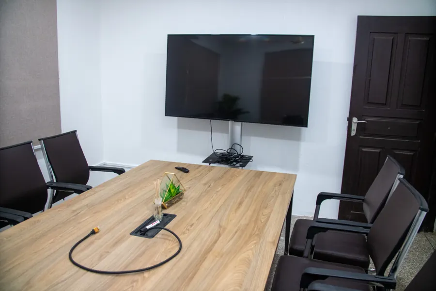 Meeting table facing a wall-mounted display at yecSpace