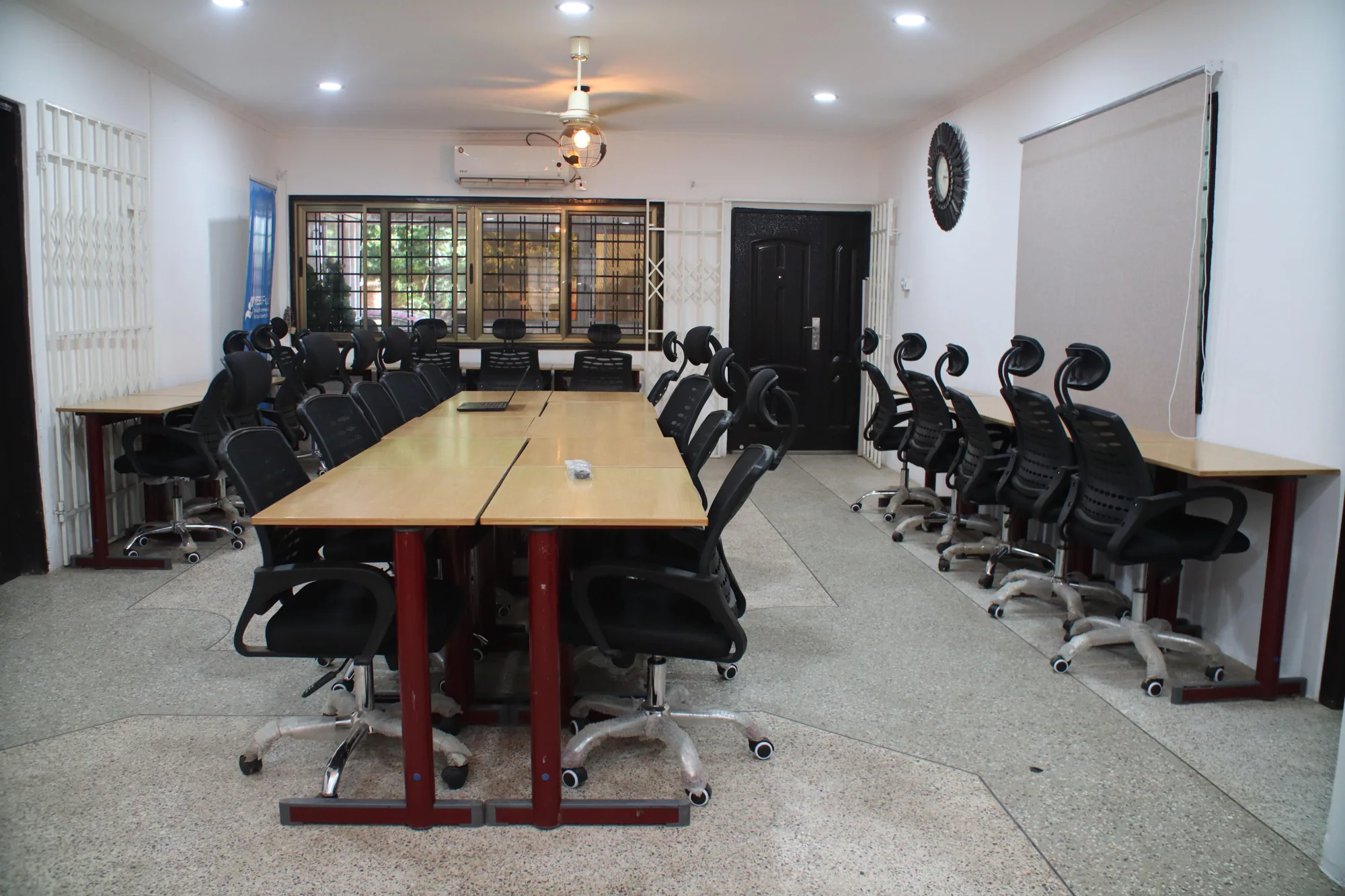 A wide view of shared wooden desks and ergonomic chairs at yecSpace